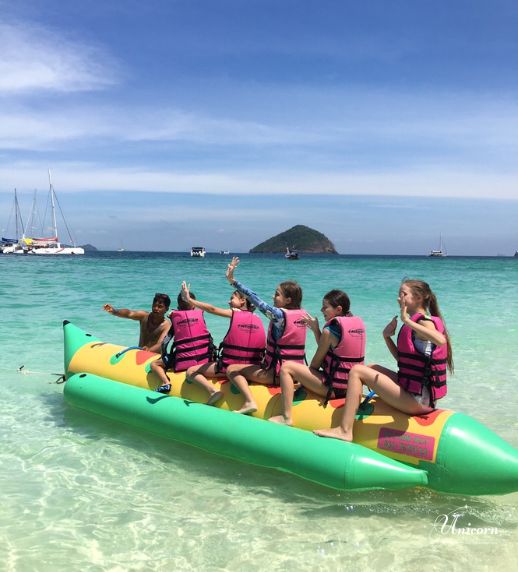 Racha Island & Coral Island Full Day Tour by Speedboat – Snorkeling & Buffet Lunch 17 Tourists riding banana boat at Coral Island Phuket