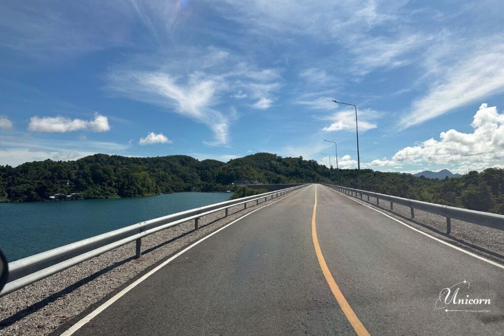 Private Transfer from Phuket to Cheow Lan Lake (Ratchaprapha Dam, Khao Sok) 8 Beautiful scenic road over Ratchaprapha Dam with blue lake and mountain views in Khao Sok.